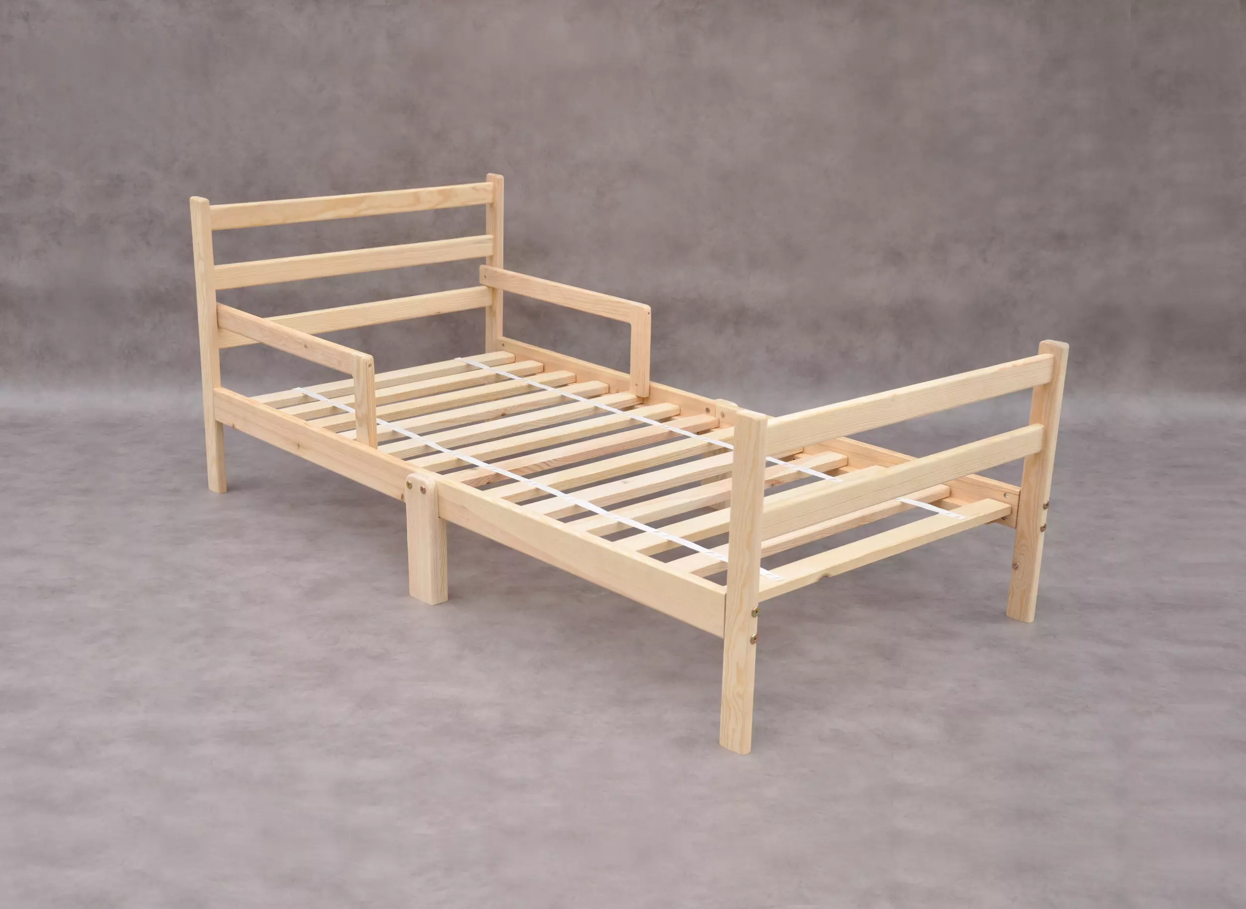 Børneseng 140x70 cm i naturtræ med sengehest, lav juniorseng i ubehandlet massivt fyrretræ til tryg overgang fra tremmeseng